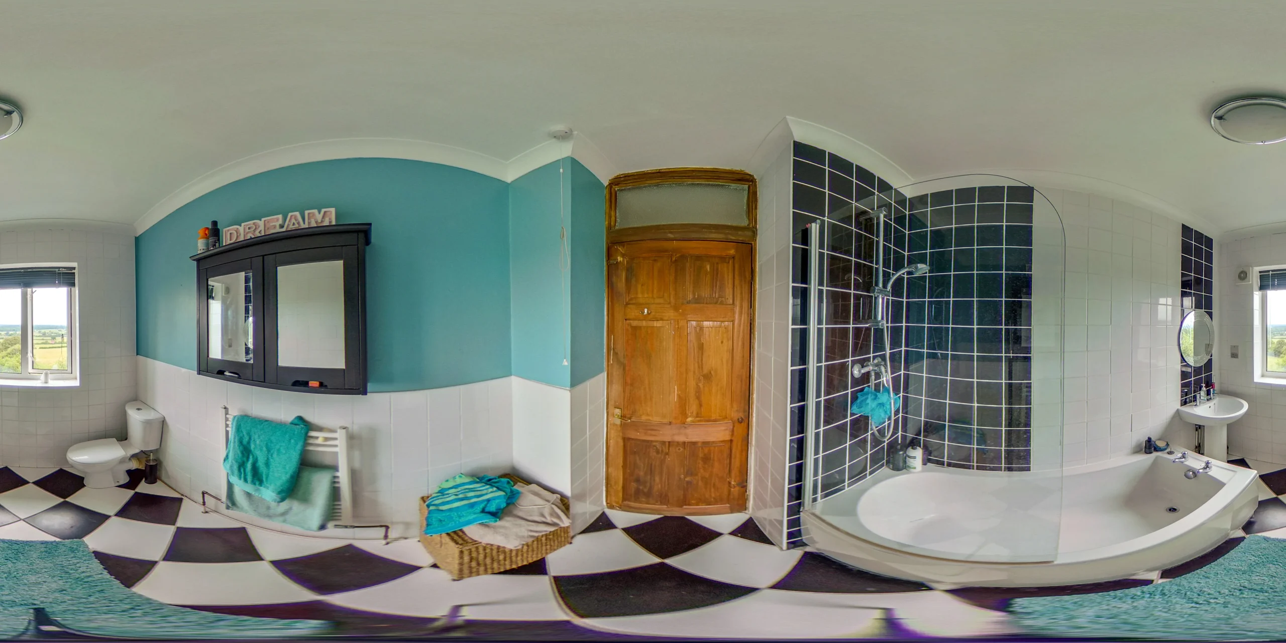 A 360 Still of a clean and modern bathroom with white tiles, a sleek bathtub, a glass shower enclosure, and a vanity with a mirror.