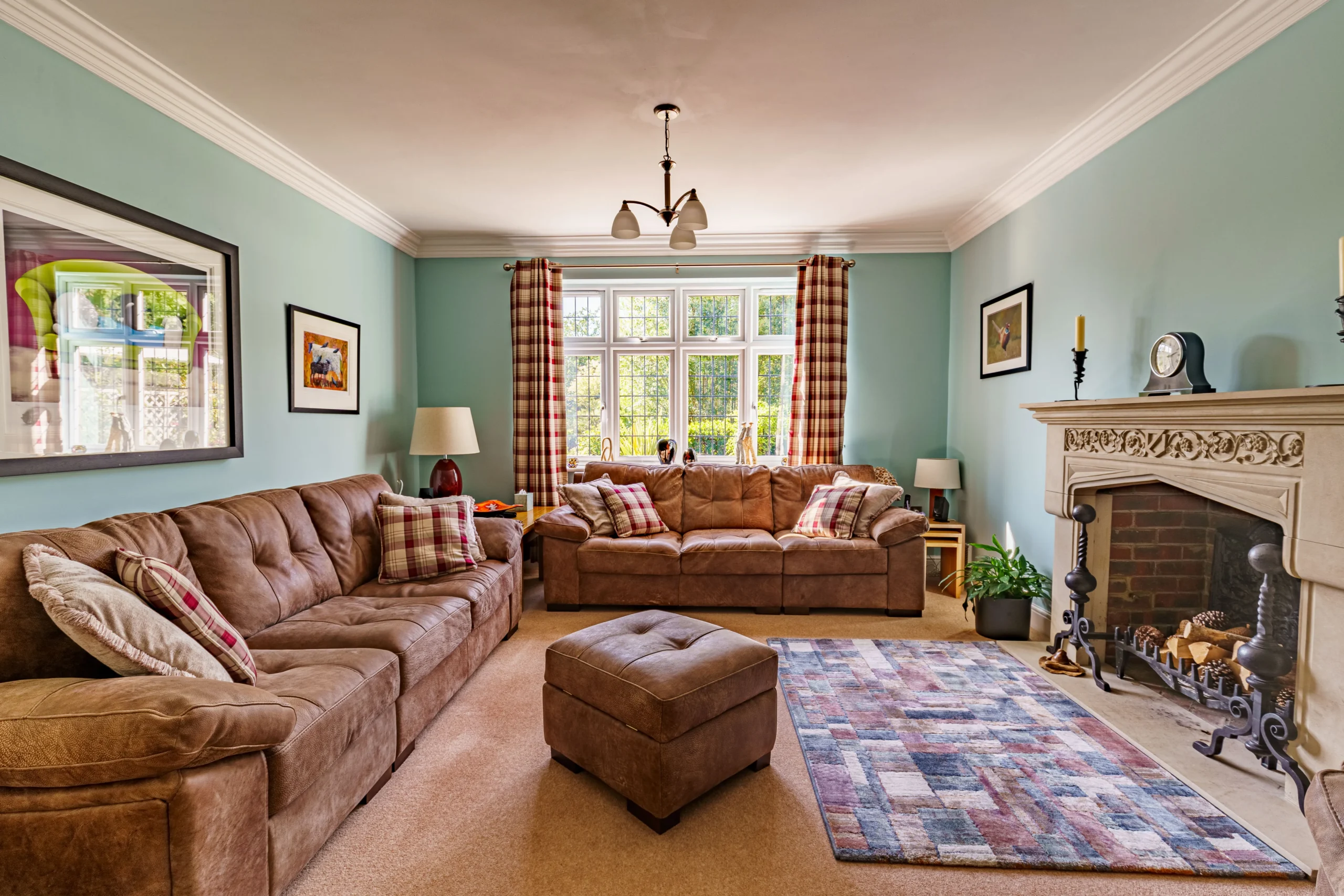 A cosy living room with sofas arranged around a fireplace, accompanied by a rug which adds to the warm and inviting atmosphere.