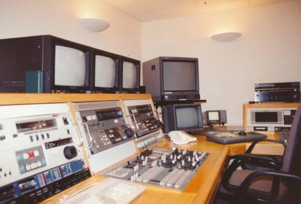 A room with multiple TVs and a computer desk in an edit suite.