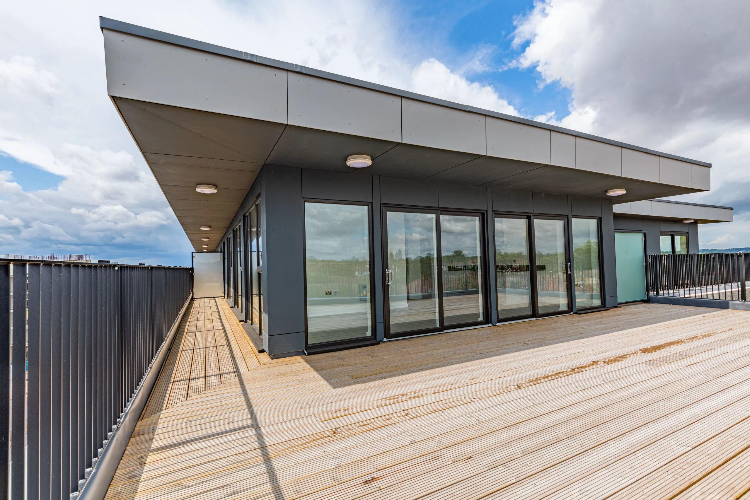 A contemporary home featuring a deck and balcony, offering a perfect blend of indoor and outdoor living spaces.