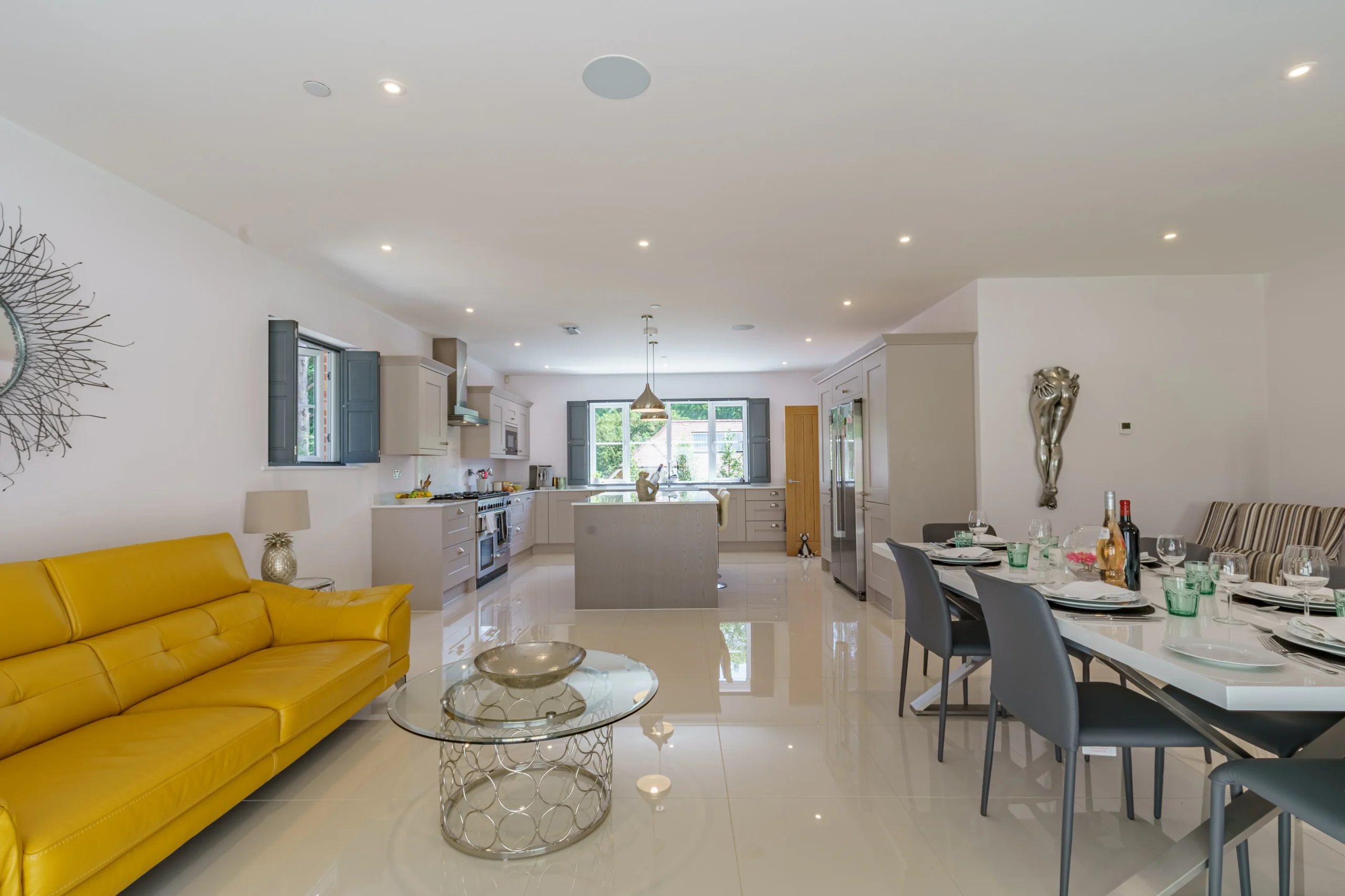 A vibrant yellow couch in a stylish open-plan living area adds a touch of luxury and warmth to the space.