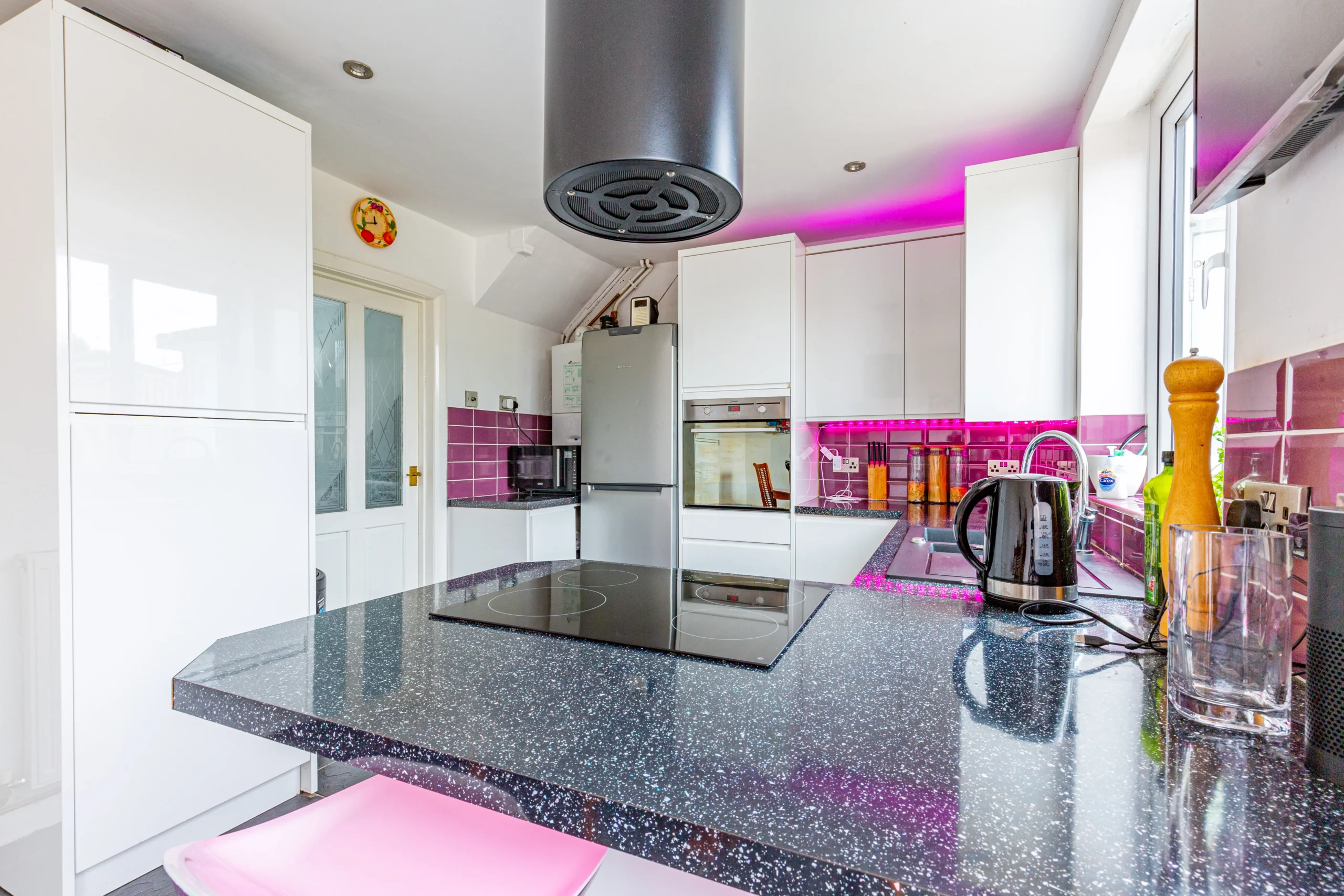 A pink, glittery urban kitchen with modern appliances and sleek countertops.