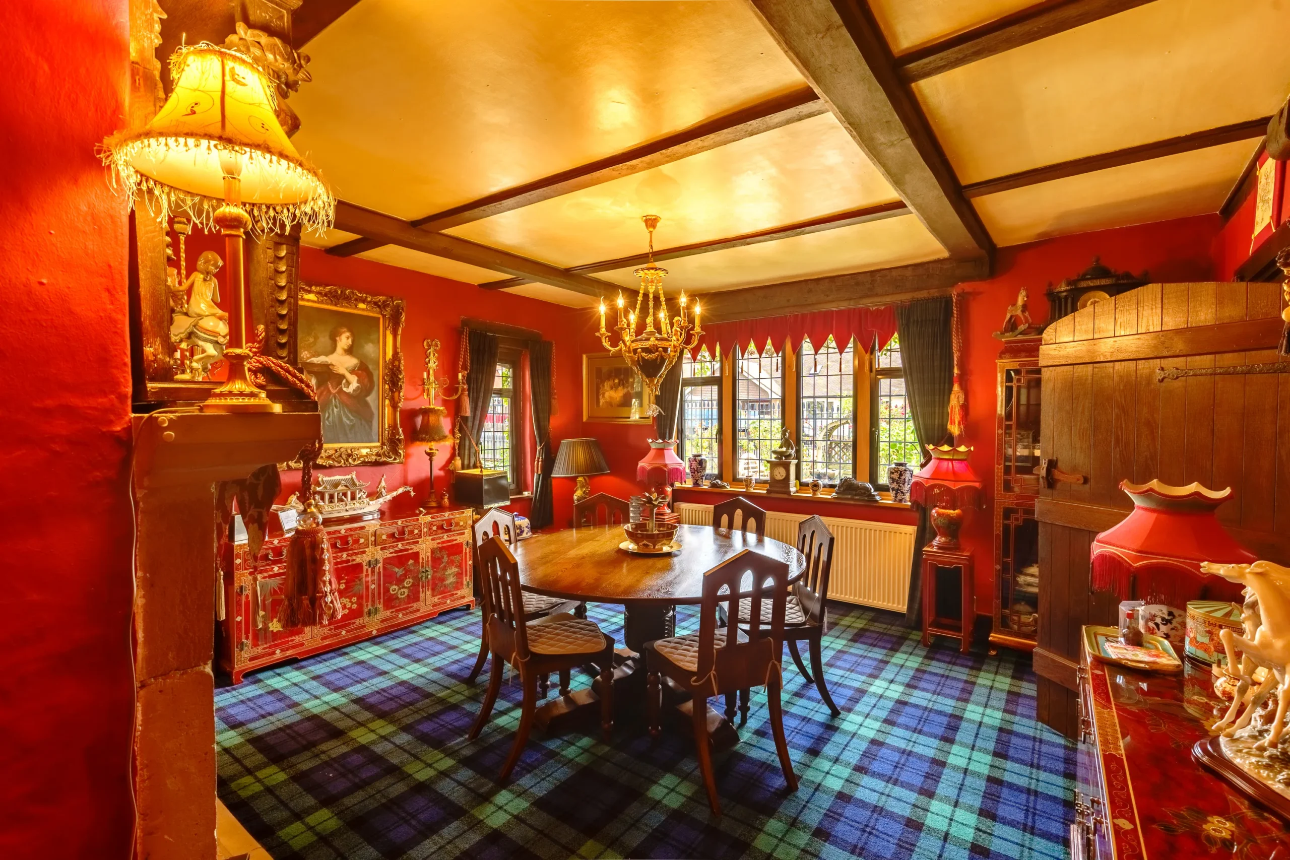 Eccentric dining room in a Scottish mansion, featuring red walls and a table.
