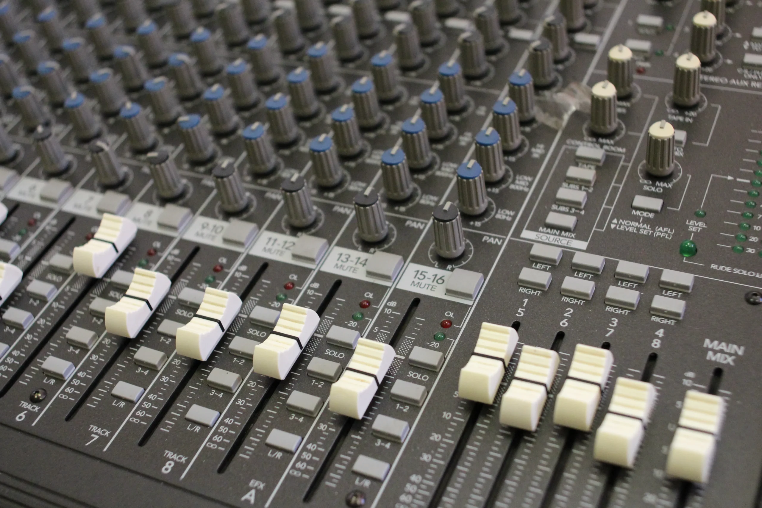 A sound desk with multiple knobs and buttons for adjusting audio levels and settings.