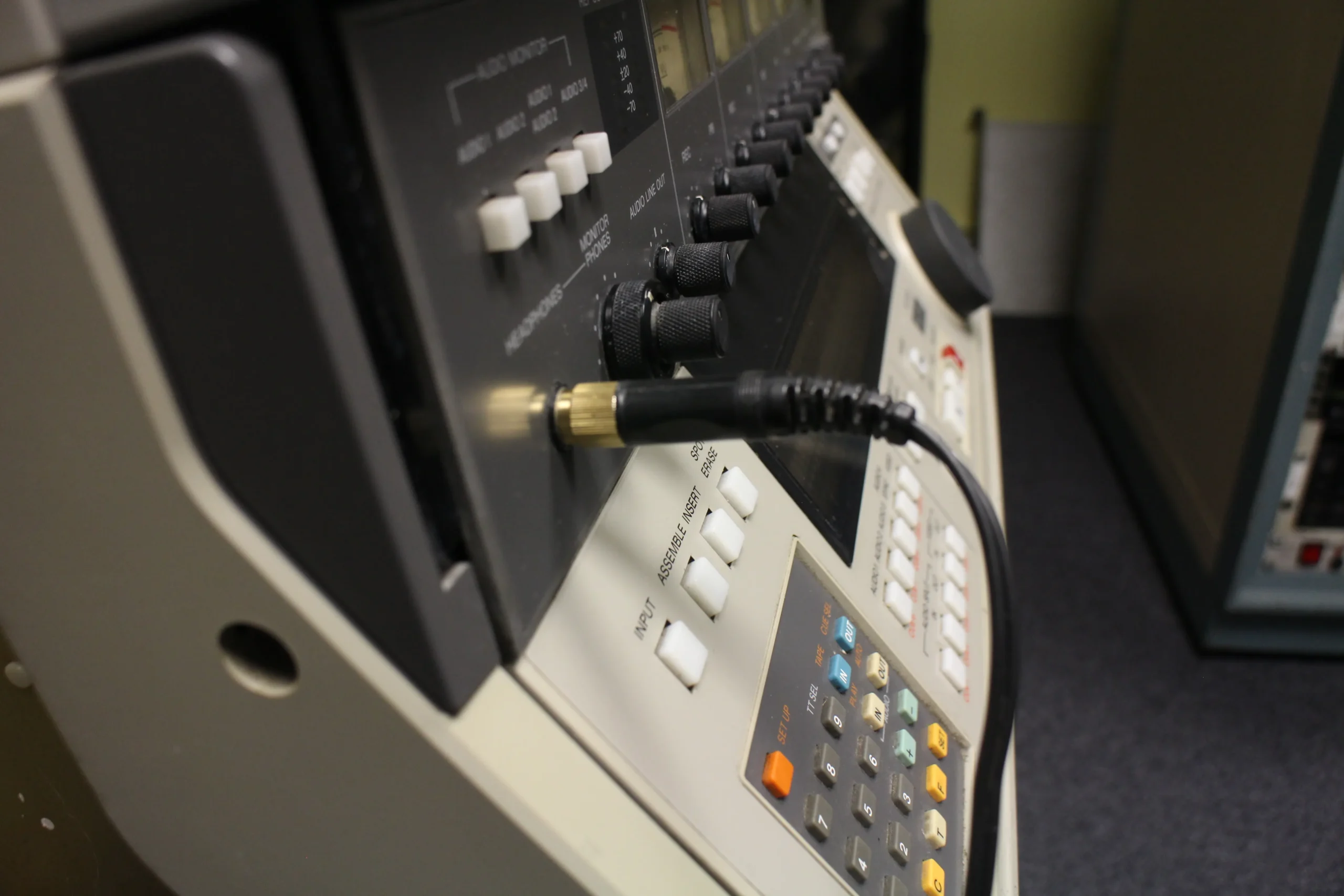 A close-up of a VCR machine with a cord attached.